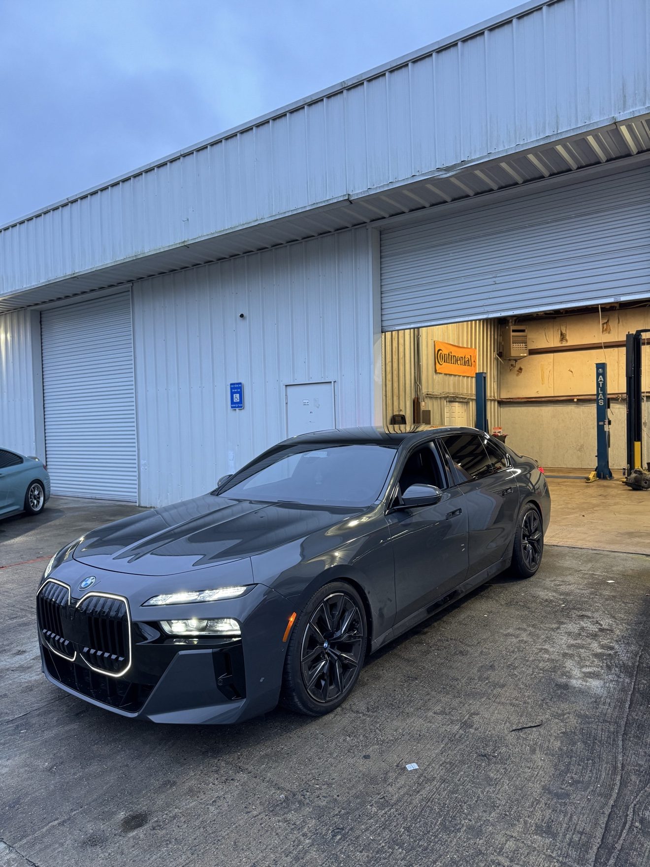 Gray BMW 7 Series sedan in front of the shop at Auto Haus Solutions in Cumming, GA