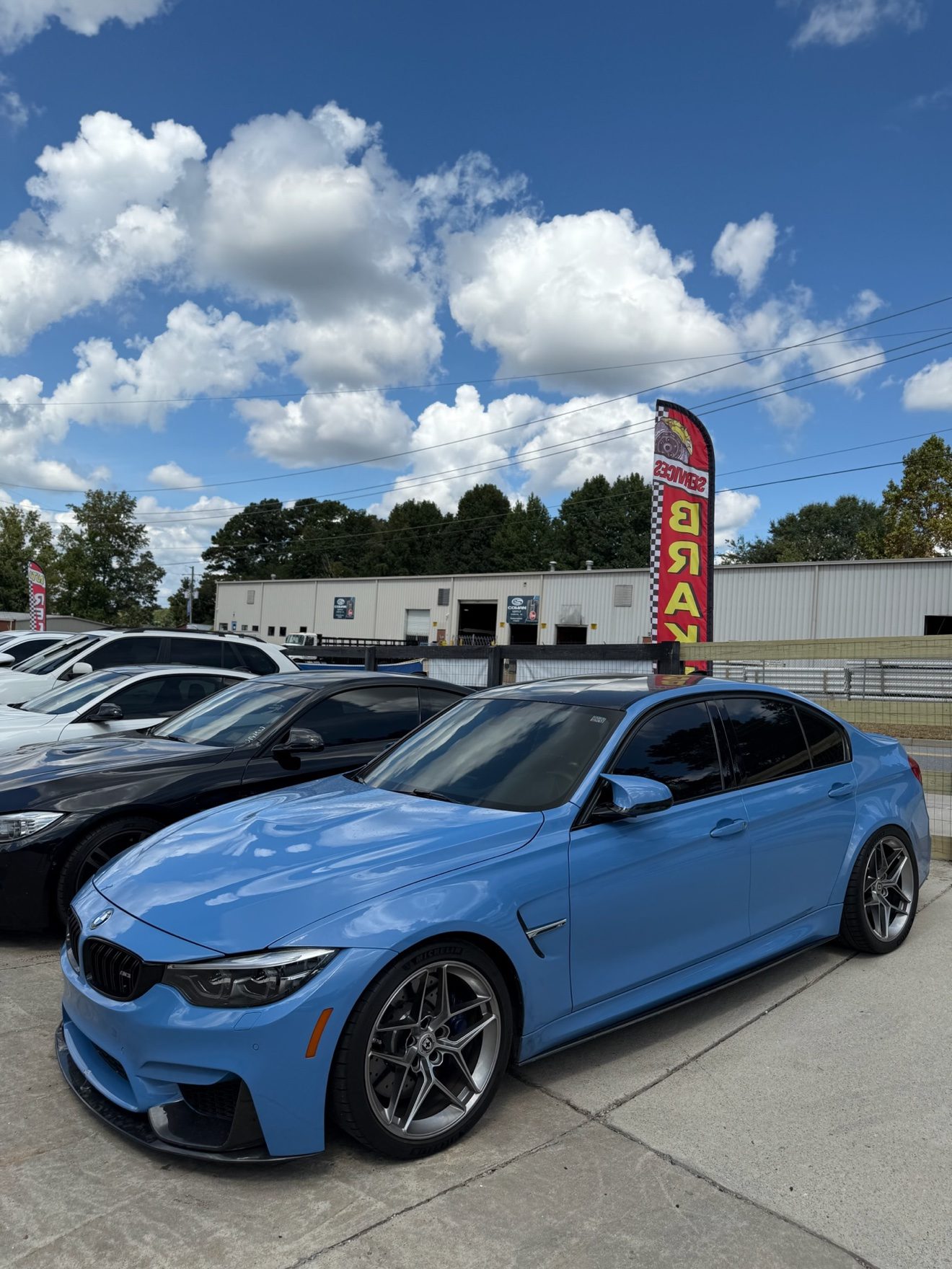 Blue BMW M3 sedan at the Auto Haus Solutions lot