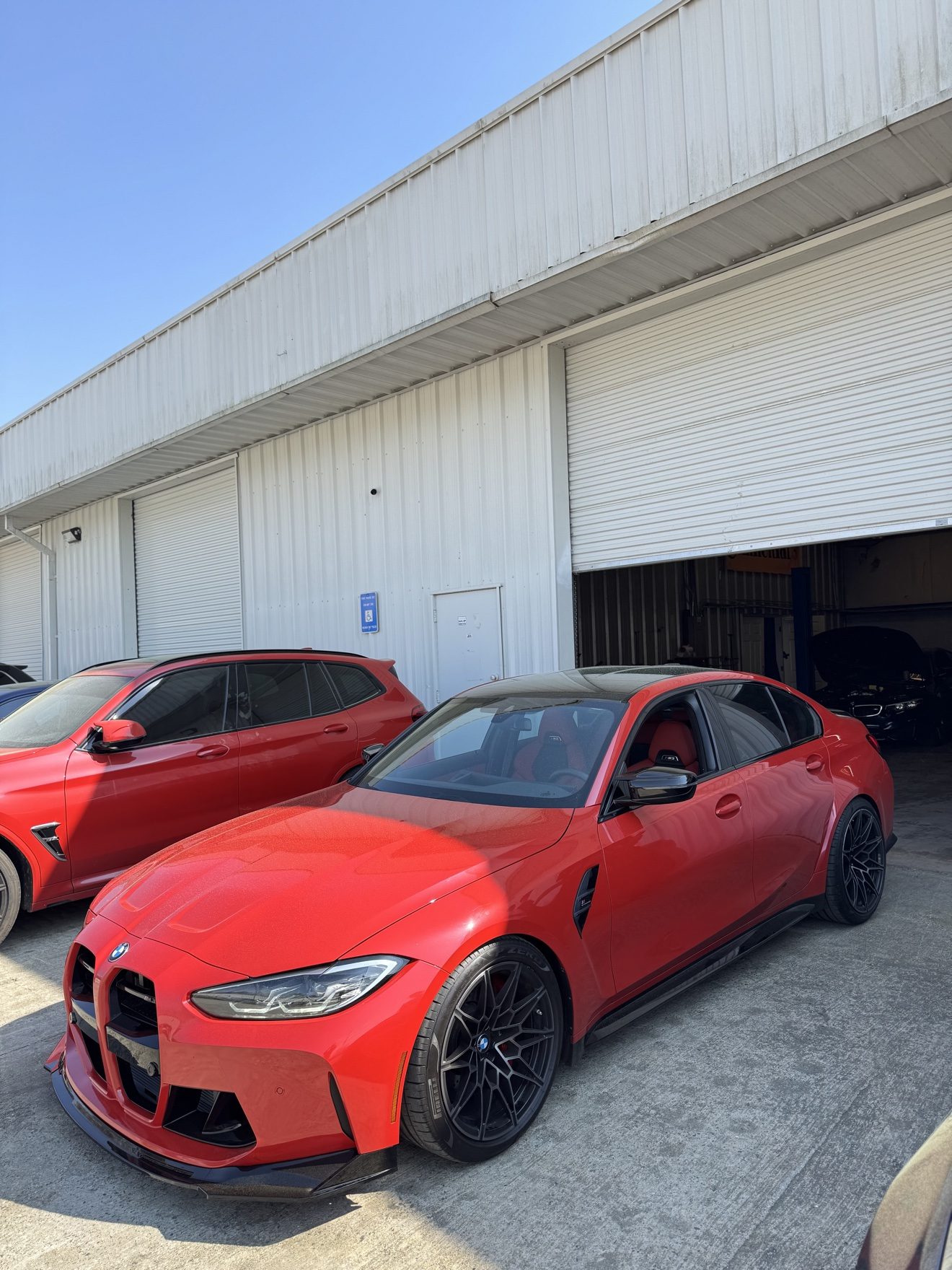 Red BMW M3 and red BMW X3M at Auto Haus Solutions in Cumming, GA