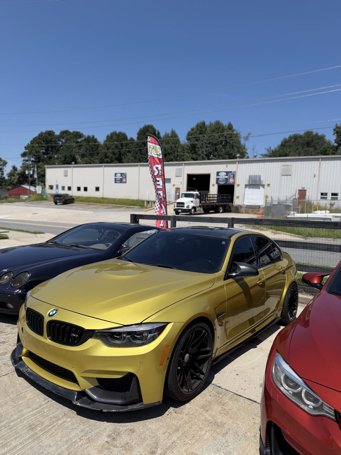 Gold BMW M3 sedan at the Auto Haus Solutions shop