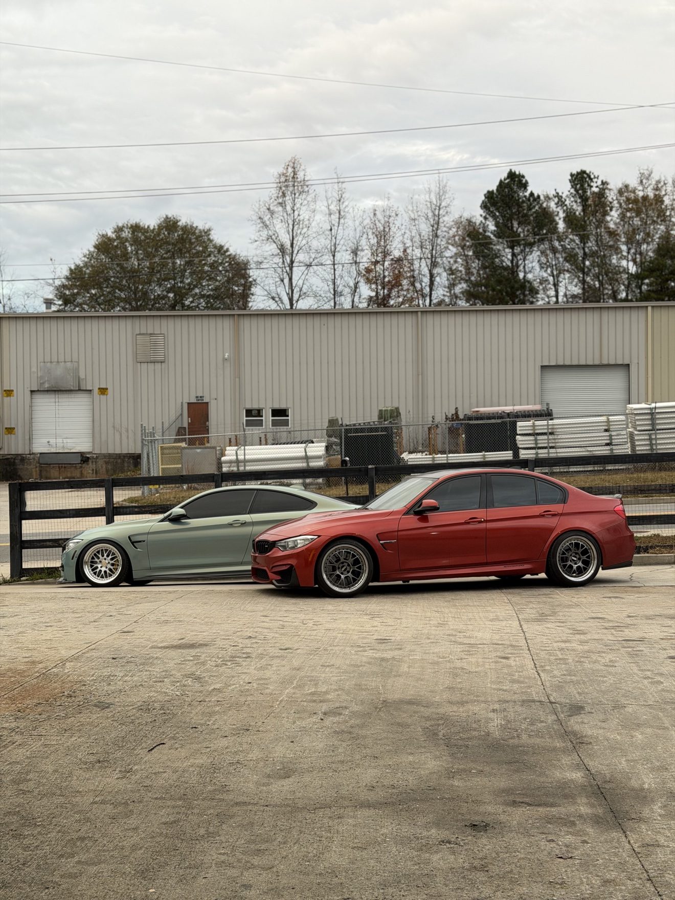 Green BMW M4 coupe and red BMW M3 sedan at Auto Haus Solutions in Cumming, GA