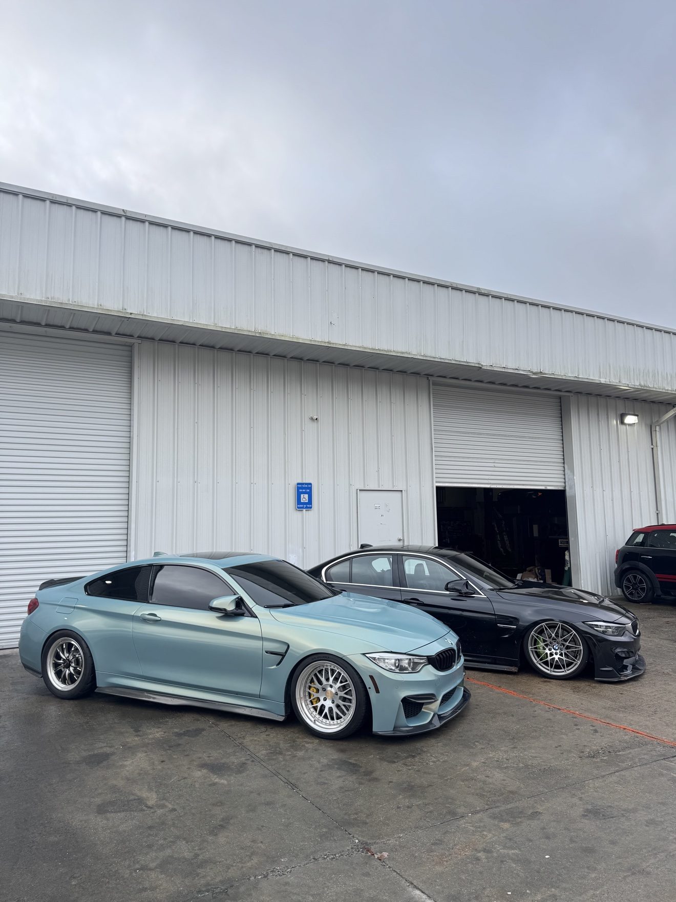 Teal BMW M4 coupe and black BMW M3 sedan at Auto Haus Solutions in Cumming, GA