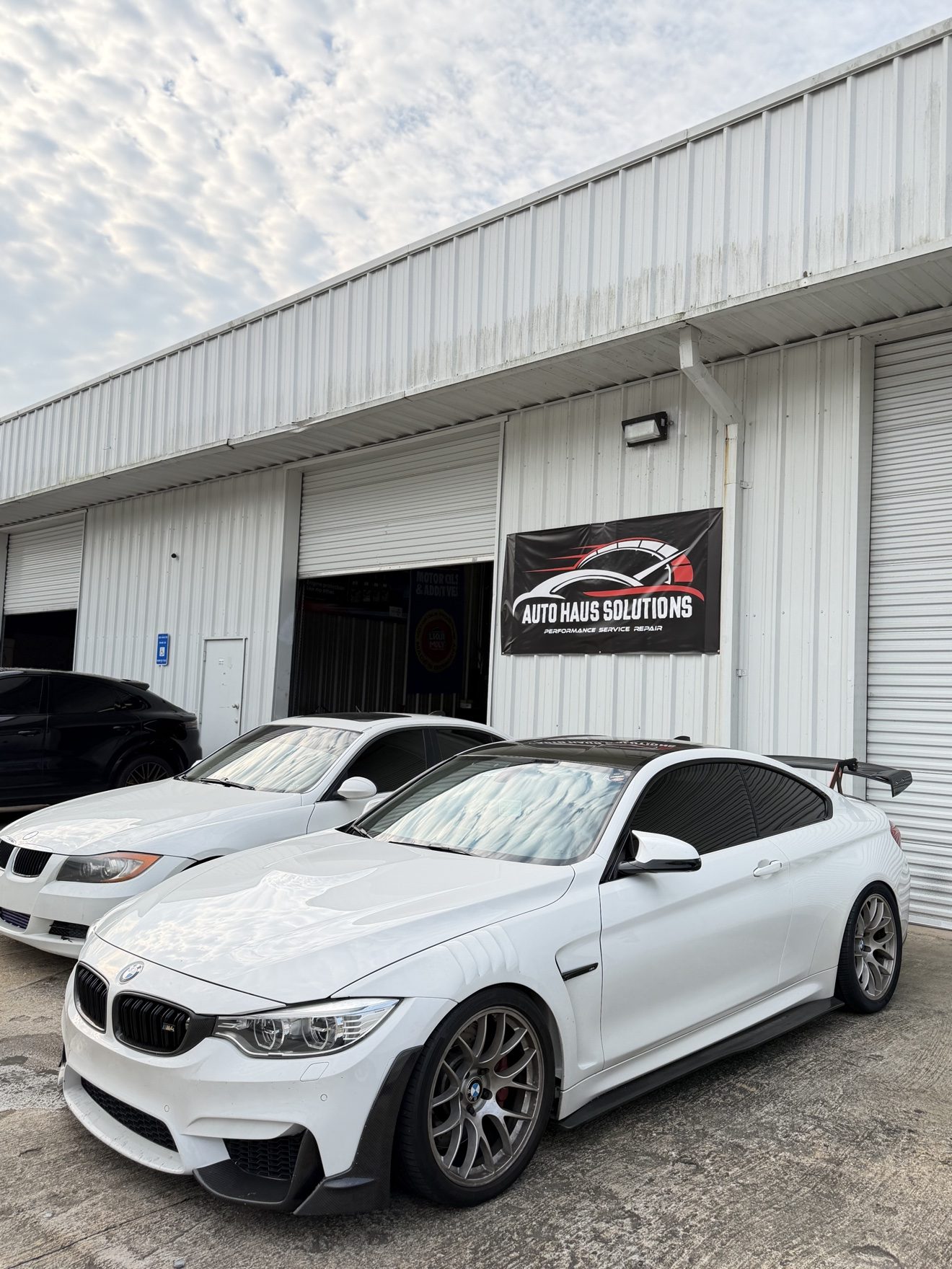 White BMW M4 coupe with rear wing at Auto Haus Solutions in Cumming, GA